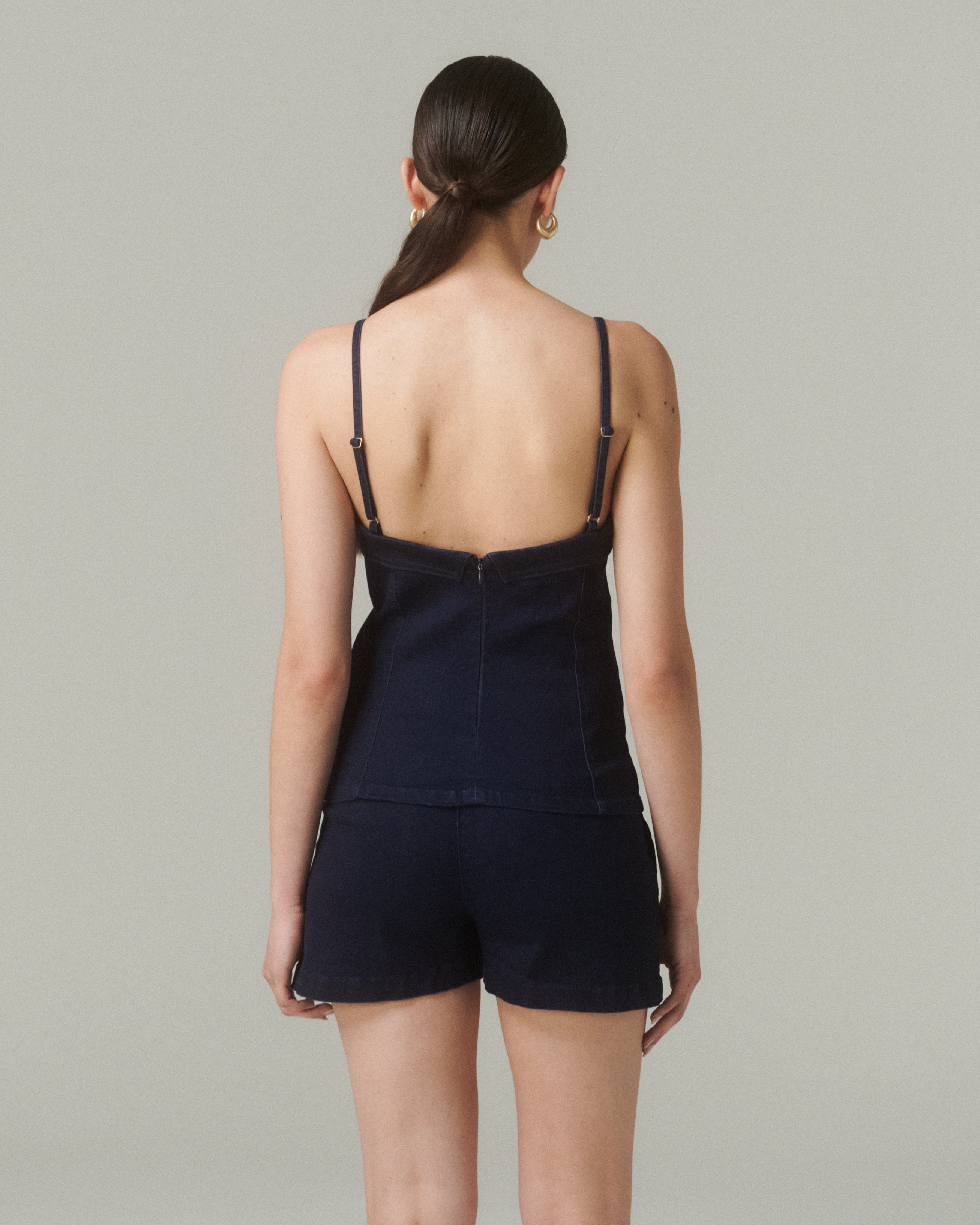 Vista trasera de la Blusa Sol Denim, mostrando el cierre en la espalda y ajuste cómodo y definido.