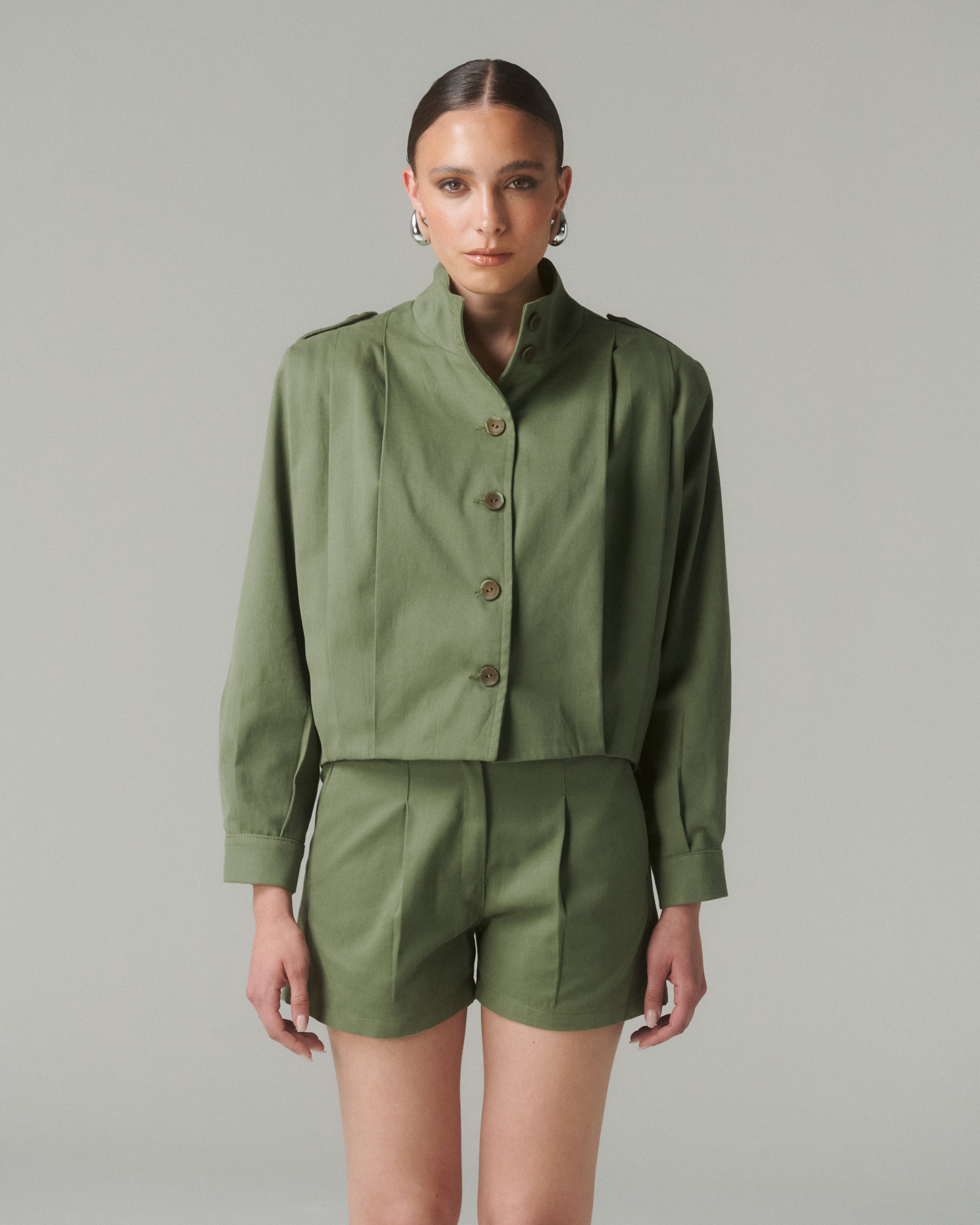 Vista de medio cuerpo del Short Lua Verde con chaqueta verde, mostrando detalle de la pretina y ajuste cómodo.