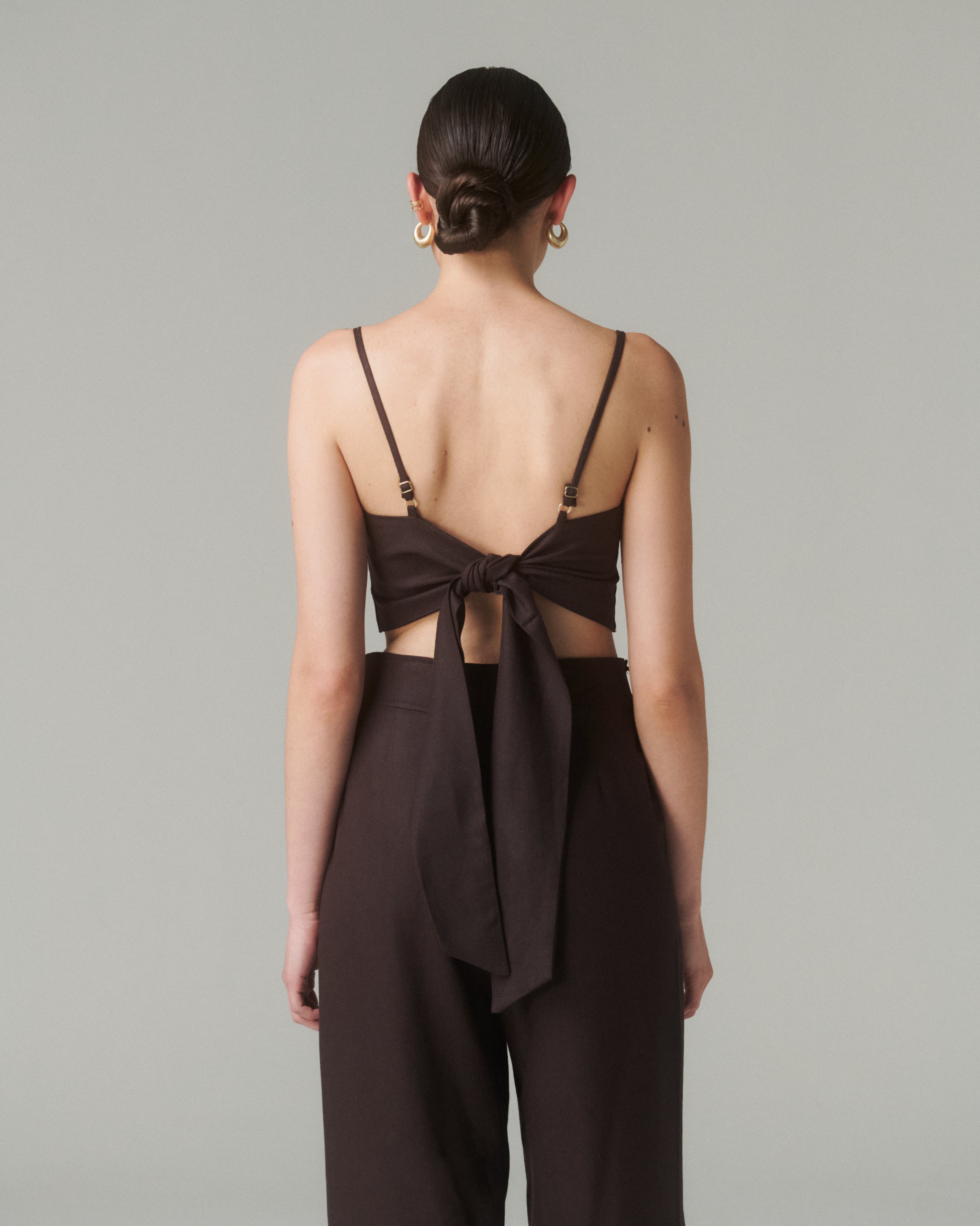 Detalle del lazo en la espalda o del tejido (textura lino-viscosa).  Enfoque suave que resalte la confección.