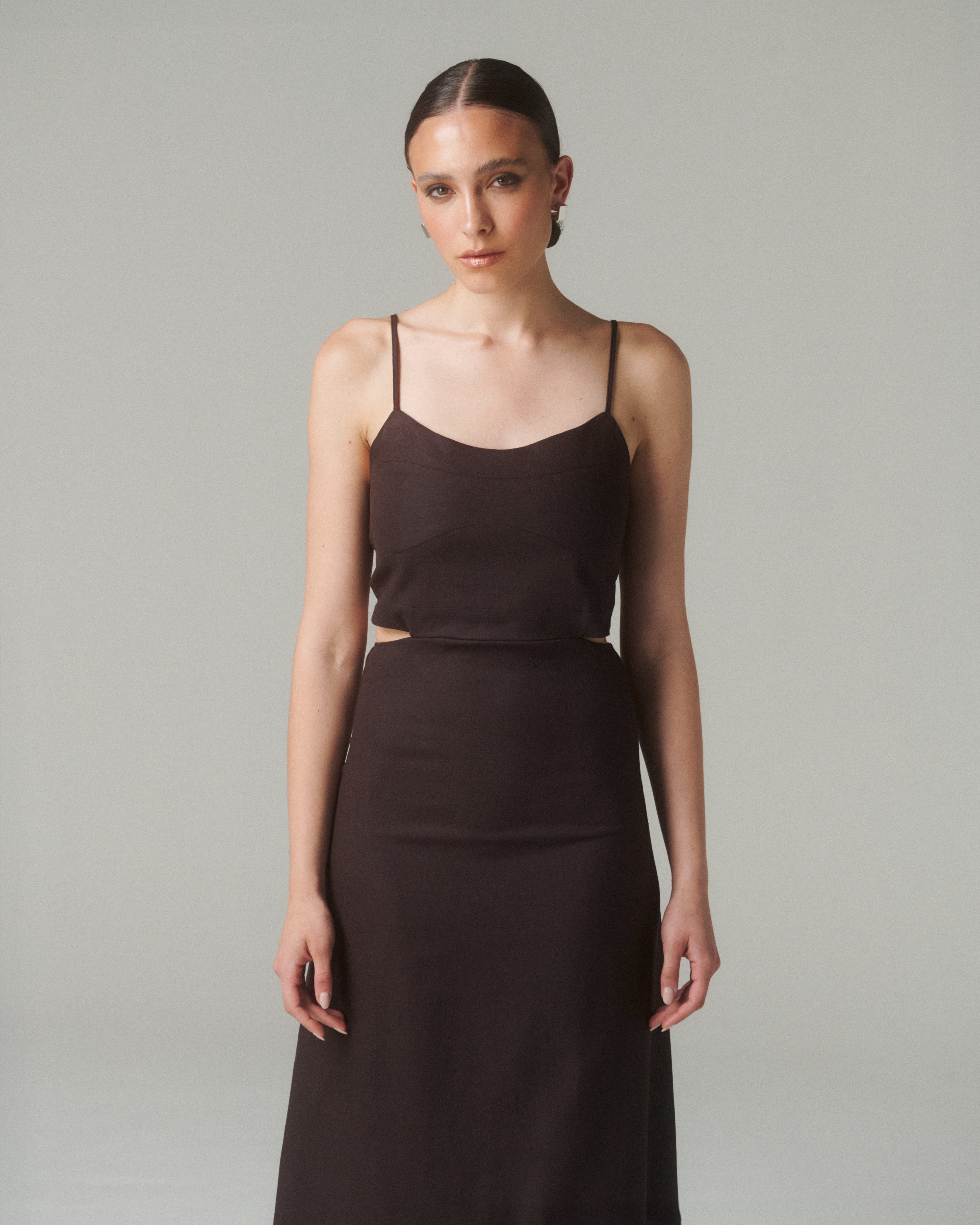 Modelo luciendo el Vestido Moa Café con escote recto y tirantes finos, destacando elegancia y comodidad.