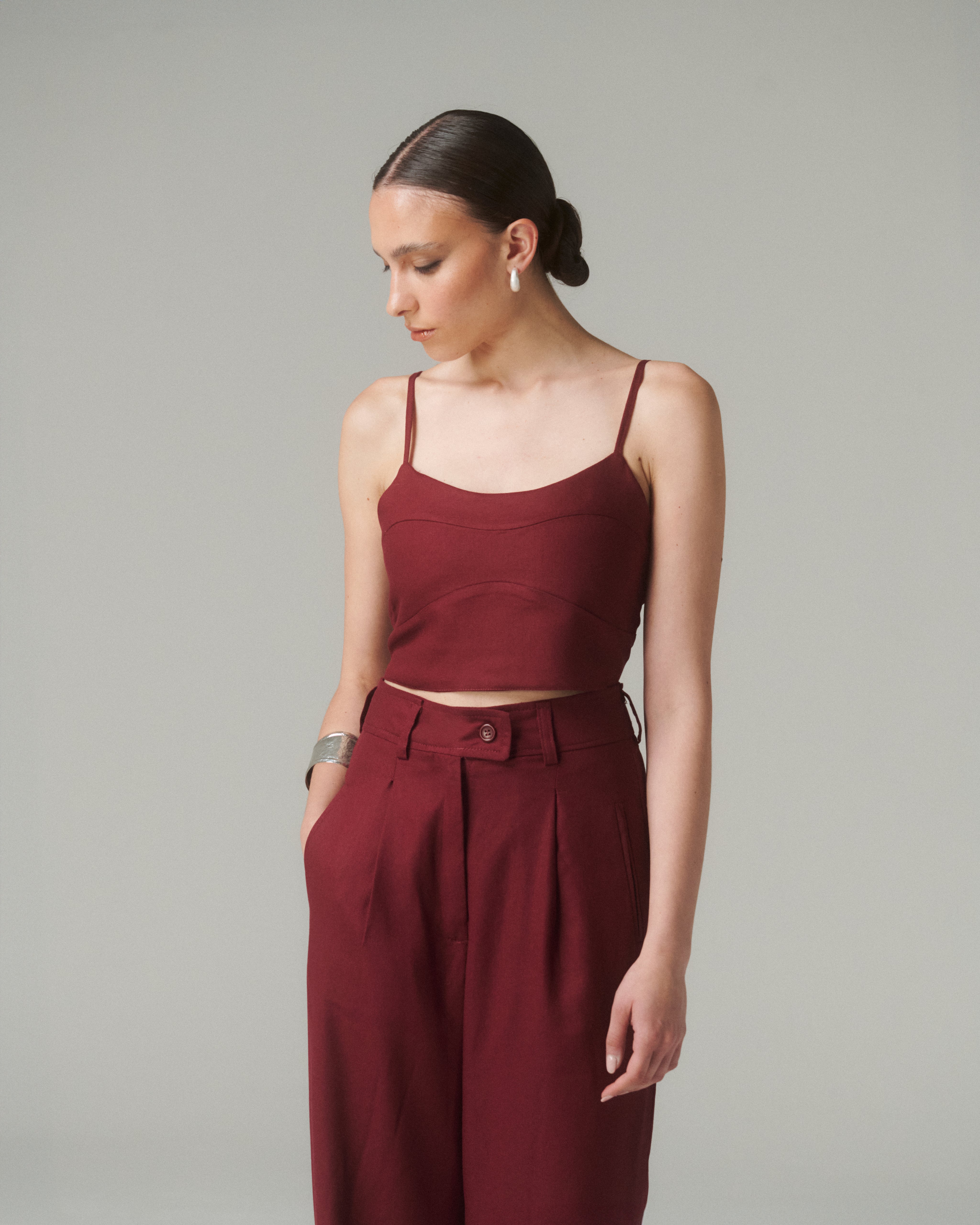 Blusa Nina Burdeo, elegante blusa burgundy de tirantes finos con diseño contemporáneo y lazo ajustable en la espalda.