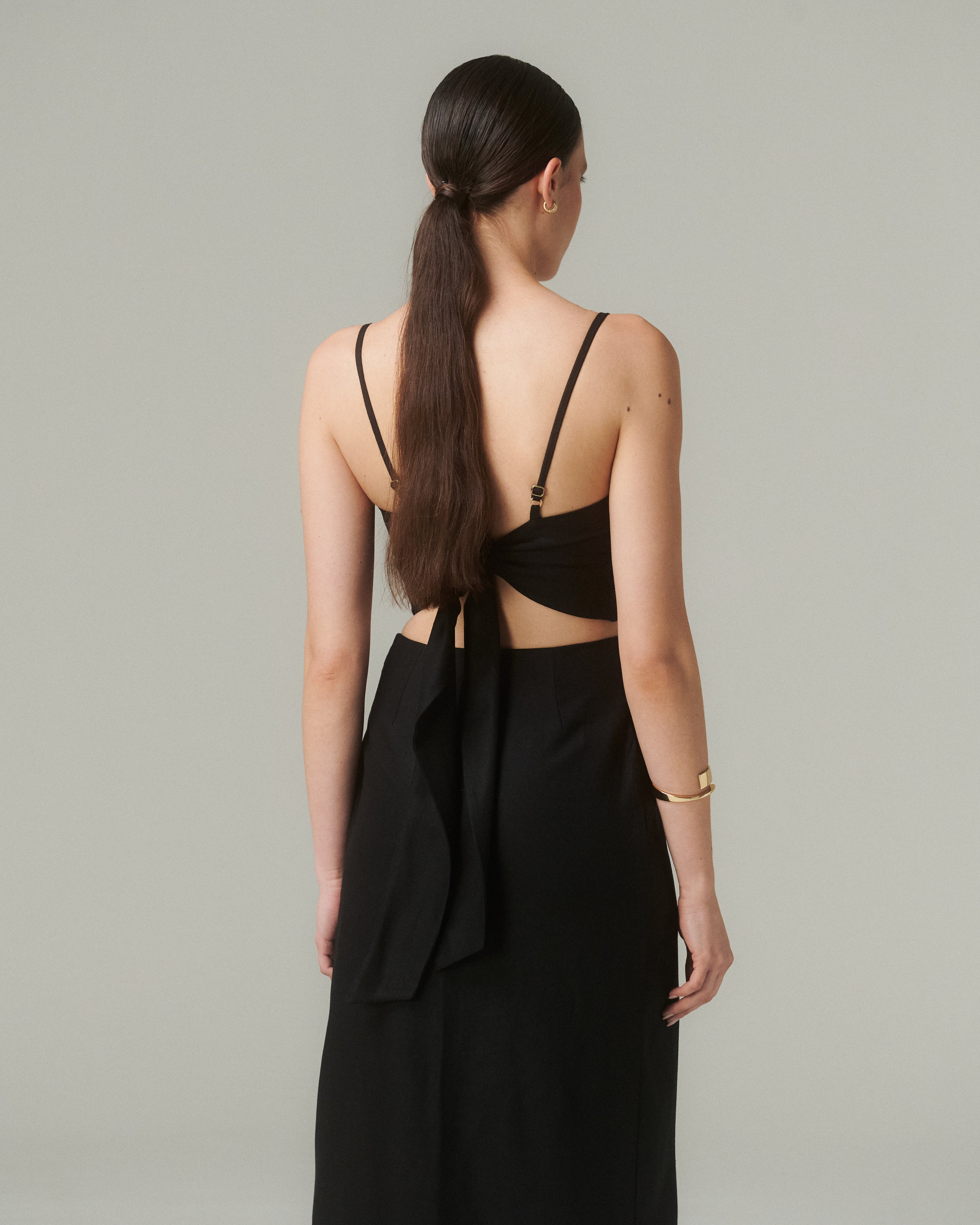 Detalle del lazo en la espalda o del tejido (textura lino-viscosa).  Enfoque suave que resalte la confección.