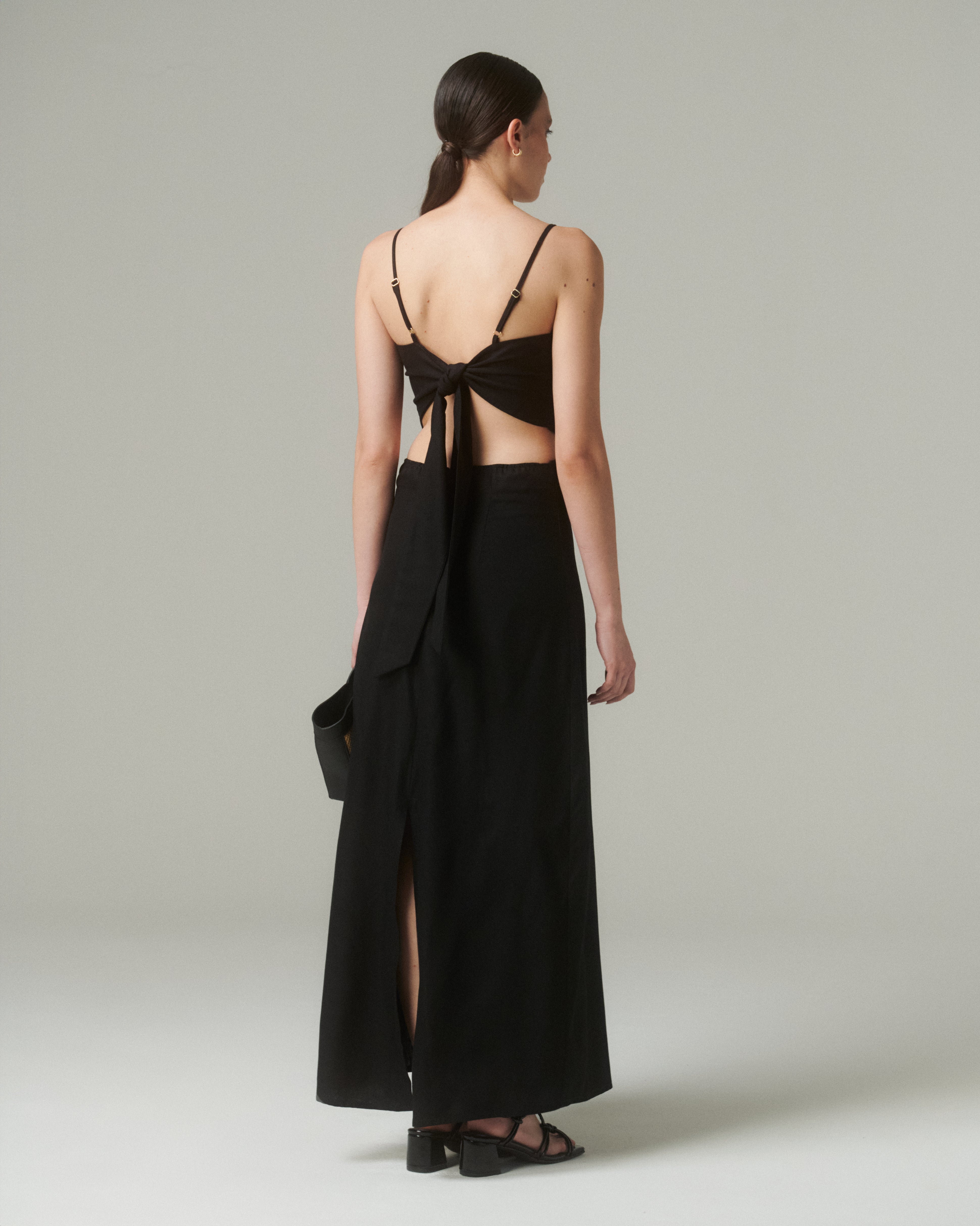 Vestido Moa Negro vista trasera con tirantes finos y lazo ajustable, diseño elegante y cómodo.