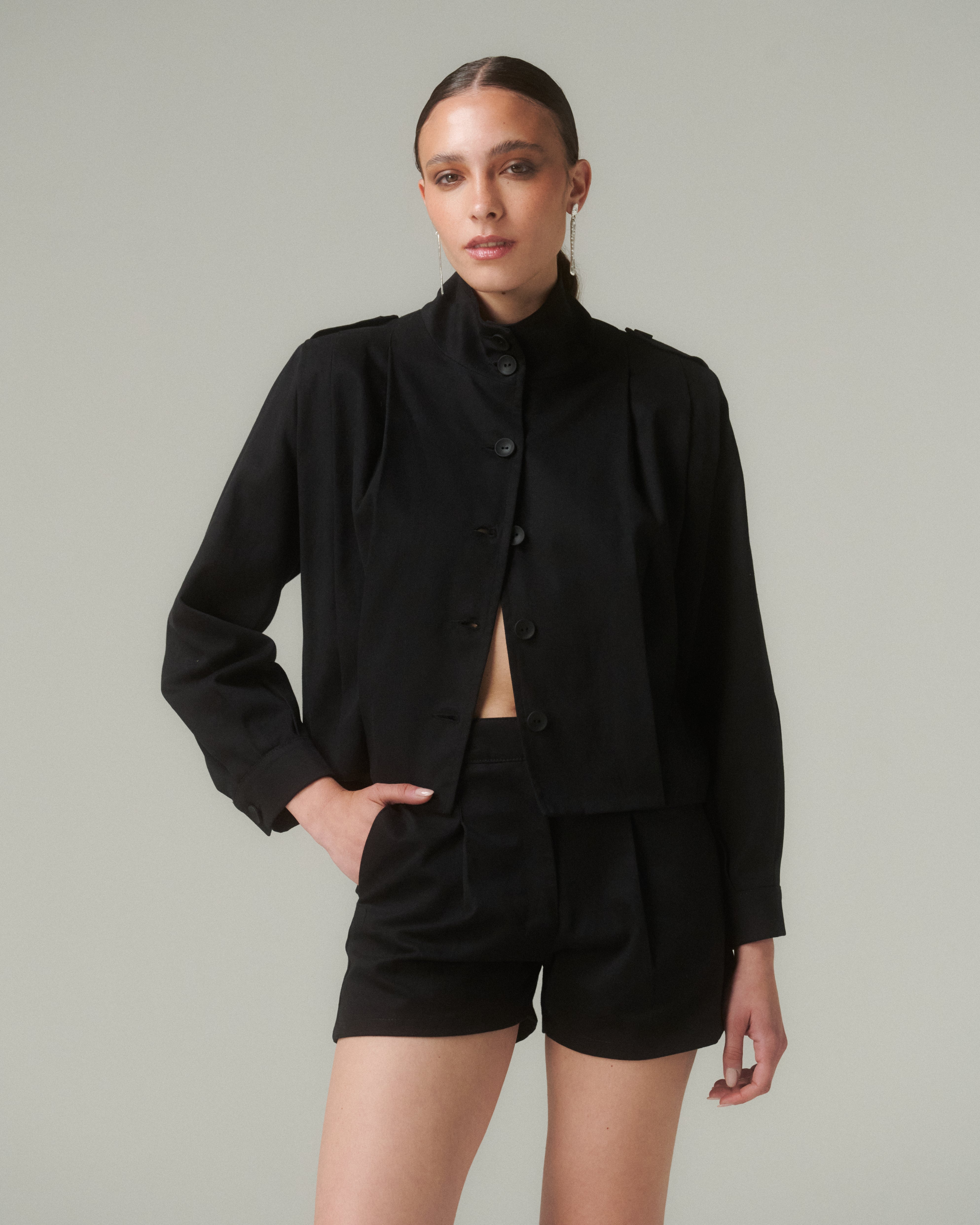 Chaqueta Bruna Negro, prenda estructurada con calce relajado, cuello subido y cierre frontal con botones.